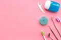 Daily oral hygiene for family. Toothbrush, dental floss and dentist instruments on pink background top view mock up