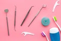 Daily oral hygiene for family. Toothbrush, dental floss and dentist instruments on pink background top view