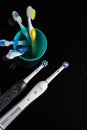 Oralcare Concepts. Pair of Professional Electric Toothbrushes In Front of Four Manual Toothbrushes Placed on One Cup