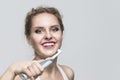 Oralcare and Dentistry Concepts. Caucasian Blond Woman Cleaning Teeth with Electric Toothbrush Posing Against Over White