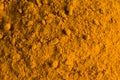 Orange abstract food background with copy space, natural dye, spice turmeric close up visa from top