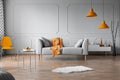 Orange accents in grey living room interior with copy space on empty wall Royalty Free Stock Photo