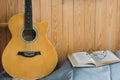 Orange acoustic guitar and open book with eyeglasses. Royalty Free Stock Photo