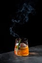 orange alcoholic cocktail with a sprig of pine needles and round ice, side view Royalty Free Stock Photo