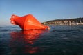 Orange anchor buoy floats on the sea.