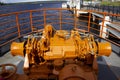 orange anchor windlass with chains on the bow of a touring boat. Royalty Free Stock Photo