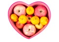 Orange and apple mixed in heart-shaped gift box on white Royalty Free Stock Photo