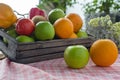 Orange and apple in a wooden crate. Fresh fruit on a wooden table with a cloth. Eating fruit helps to lose weight. fruits and Royalty Free Stock Photo