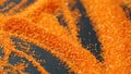 Orange artificial sand for sand therapy on a black table