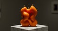 Abstract Orange Artistic Candle with Unique Shape on Marble Stand Royalty Free Stock Photo