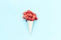 Orange autumn flowers in waffle cone on light blue Royalty Free Stock Photo