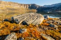 Orange autumn greenlandic tundra landscape with big stone and lake in the background, Nuuk, Greenland