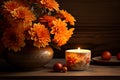 Orange autumnal flowers in vase and lit candle on wooden background