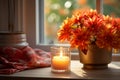 Orange autumnal flowers in vase and lit candle on wooden background