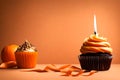 Orange backdrop with a chocolate cupcake with a candle