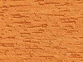 Orange background facade plaster . Monolithic plaster decorative backdrop. Single layer scraped cement plaster wallpaper. Brown ex