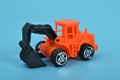 An orange backhoe loader isolated on a blue background