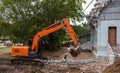 Orange backhoe to dismantle the cement crematorium