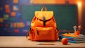 Orange backpack, books, pencils lie on the table, on a blurred background
