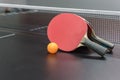Orange ball with red table tennis racket on black table Royalty Free Stock Photo