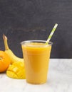 Orange, Banana and Mango Smoothie in a Plastic Disposable Cup Royalty Free Stock Photo