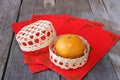 Orange in a basket on old wooden board with Chinese red envelope packet or ang pao background. Happy Chinese new year concept. Royalty Free Stock Photo