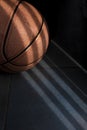 An orange basketball ball on a dark blue floor. Royalty Free Stock Photo