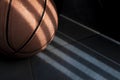 An orange basketball ball on a dark blue floor. Royalty Free Stock Photo