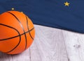 Orange basketball ball with flag Alaska on wooden parquet. Close-up image of basketball ball over floor in the gym. Basketball Royalty Free Stock Photo