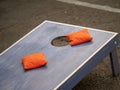 Orange beanbags sitting on blue cornhole board platform Royalty Free Stock Photo