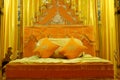 Orange bed with pillows and decorated with golden curtains