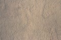 Orange or beige embossed text. The background is a concrete wall of sand color. Texture of a fragment of a wall of a modern