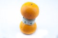Orange being squeezed by measure tape
