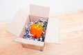 Orange bell pepper wrapped up in a box