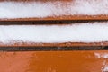 Orange bench covered in snow