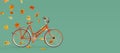 Orange bicycle arriving with falling dry leaves on green background. Autumn is coming concept image