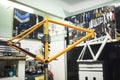 Orange bicycle frame held on a stand in a mechanical bike repair shop