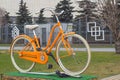 Orange bike with white tires in the Park on a pedestal