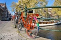 Orange bike with LGBT flag parked on a bridge in Amsterdam, Netherlands Royalty Free Stock Photo