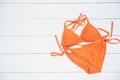 orange bikini rests on a wooden floor -summer and travel cocept.