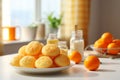 Orange biscuit balls snack cookies desert on white plate on kitchen table in sunny daylight interior