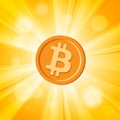 Orange bitcoin cryptocurrency in bright yellow rays of sun