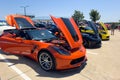 Orange and Black Chevrolet Corvette with hood open at local outside car show.