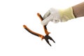 Orange and black pliers in the hand in white glove isolated on white background Royalty Free Stock Photo