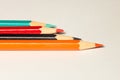 Orange, black, red, blue pencils bright pencils on a on light paper Royalty Free Stock Photo