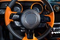 Orange black steering wheel in the car.