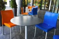 Orange and Blue Chairs and Round Tables in Outdoor Cafe