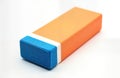 Orange, blue eraser on white background. Simple rectangular shape. Stationery item for removing marks. Versatile tool for