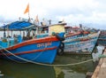 orange and blue fishing motor boats lined up in a fishing sea harbor Royalty Free Stock Photo