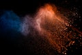 Orange blue  powder explosion on black background.Orange blue color dust splash clouds Royalty Free Stock Photo